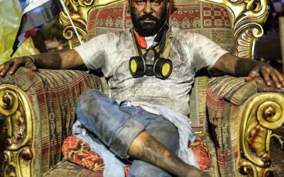 حقيقة صورة متظاهر عراقي جالس على كرسي أحد المسؤولين