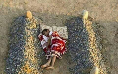 حقيقة صورة الطفل السوري الذي ينام بين قبري أبويه