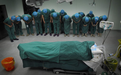 حقيقة صورة الأطباء المُنحنين أمام جثة زميلهم في سوريا